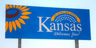 billboard with the worlds &quot;Kansas welcomes you&quot; and a sunflower